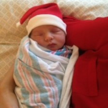 Newborn baby wearing Santa hat