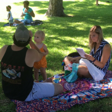 Mom, dad, and toddler on a picnic blanket