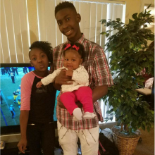 Older brother holding baby sister, middle sister standing next to them