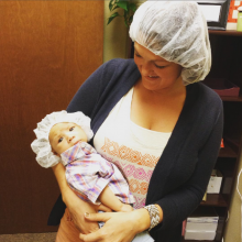 Mother holding infant son, both wearing hair nets
