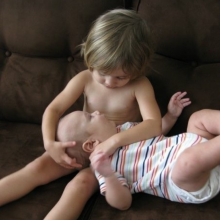 Toddler holding baby brother