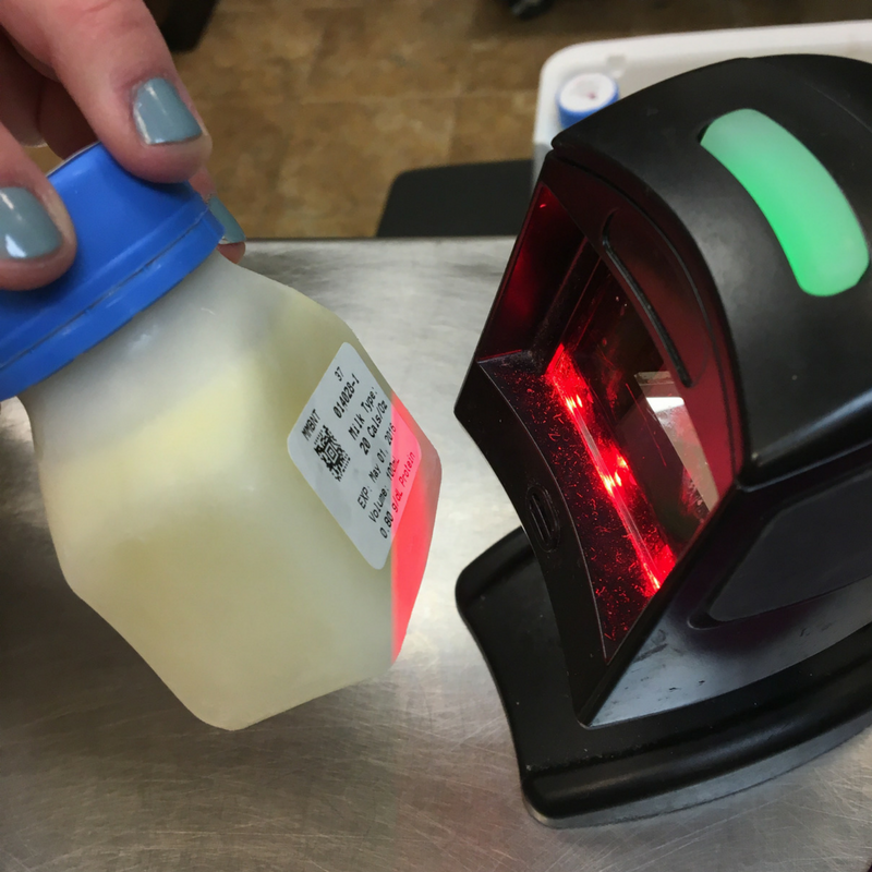 Bottle of pasteurized donor human milk being scanned by its QR code