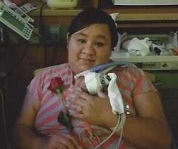Mother holding newborn in NICU