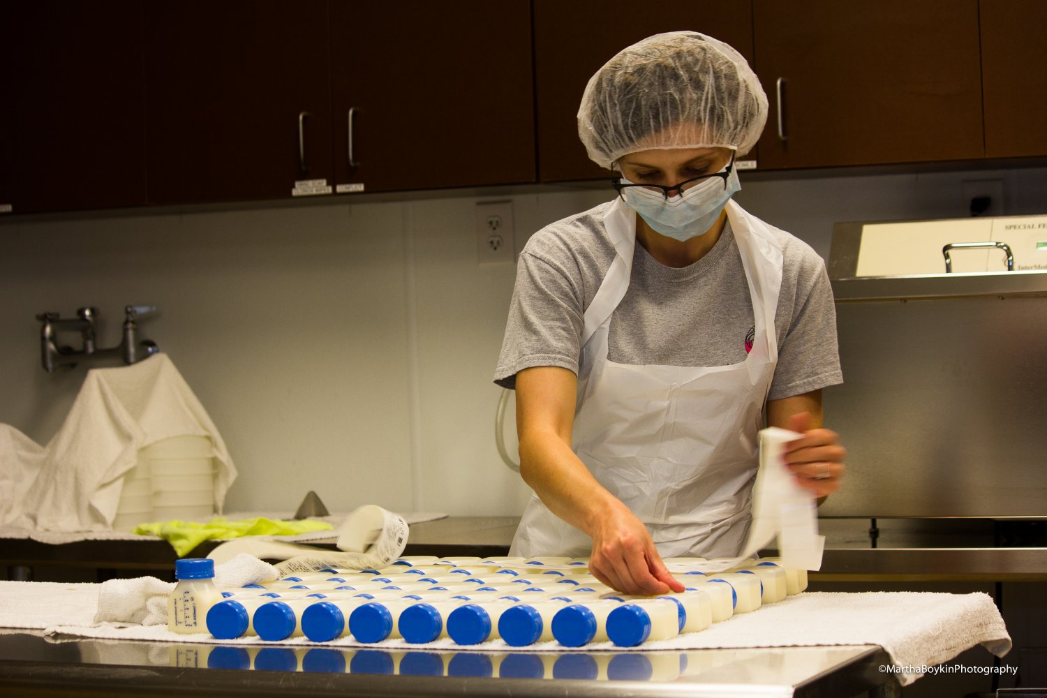 Lab technician placing labels on bottles of donor human milk