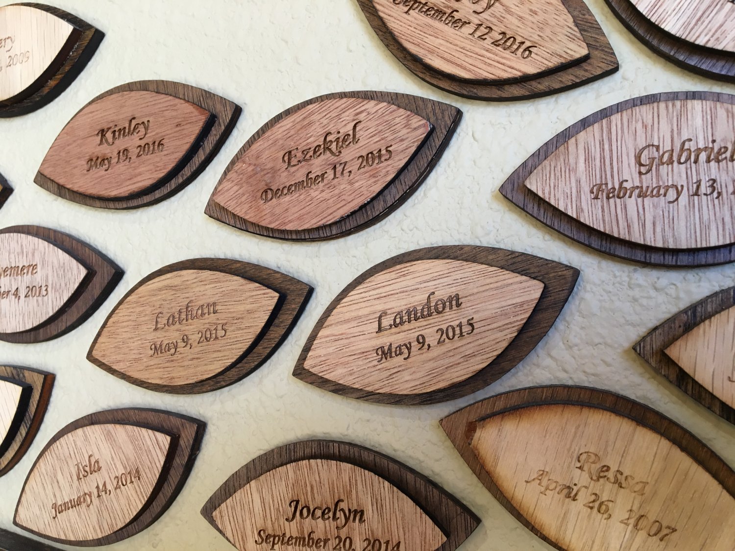 Wooden commemorative leaves engraved with babies' names and birth dates