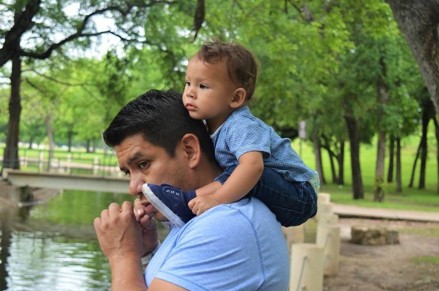 Father with toddler son sitting on his shoulders