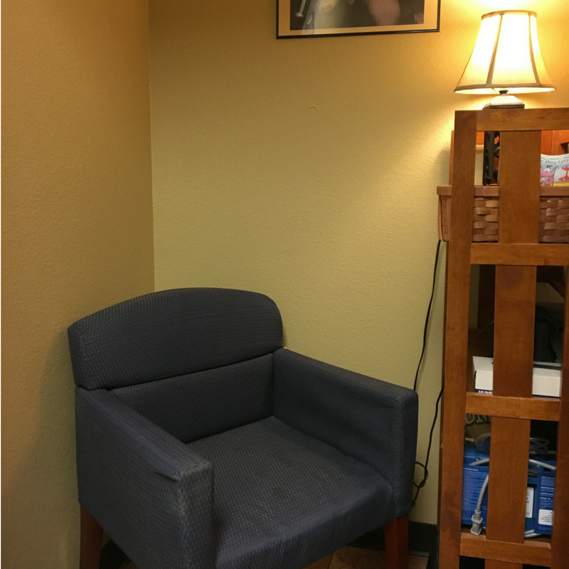 Small room reserved for pumping with chair, lamp, and shelf