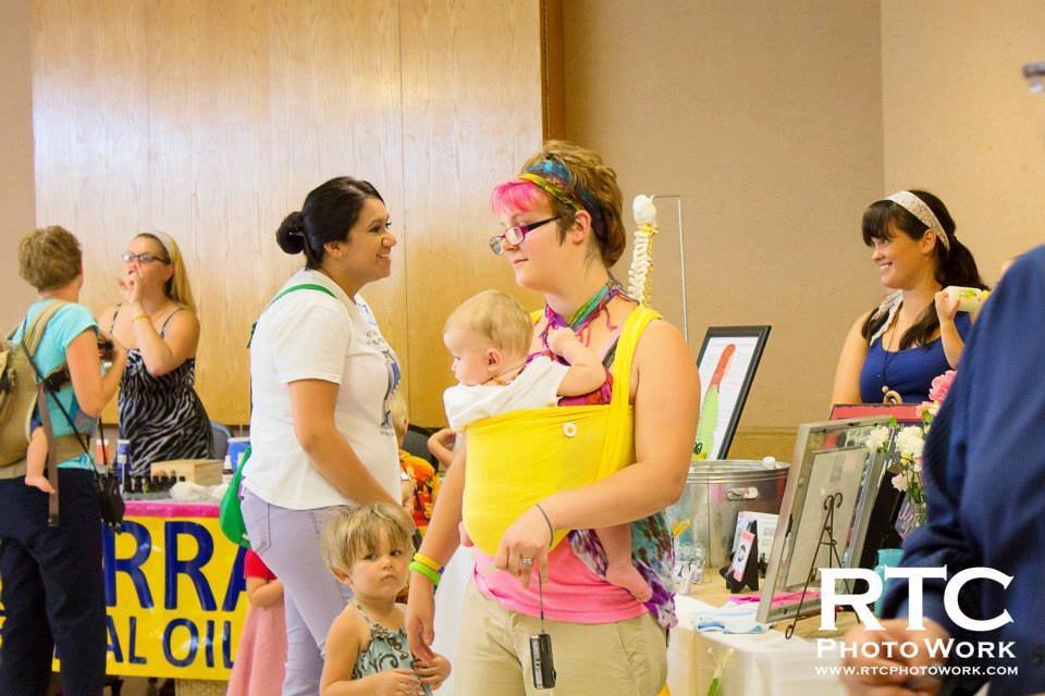 Mother, holding her baby, looking at silent auction items
