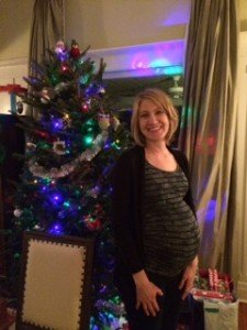 Pregnant woman standing in front of Christmas tree