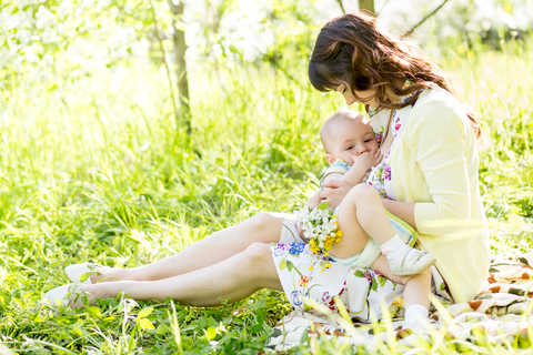 Mother breastfeeding baby outdoors