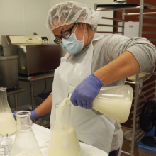 Lab technician pouring donor breastmilk into a flask