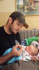 Father feeding infant son breastmilk