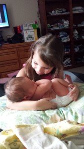 Young sister holding infant brother
