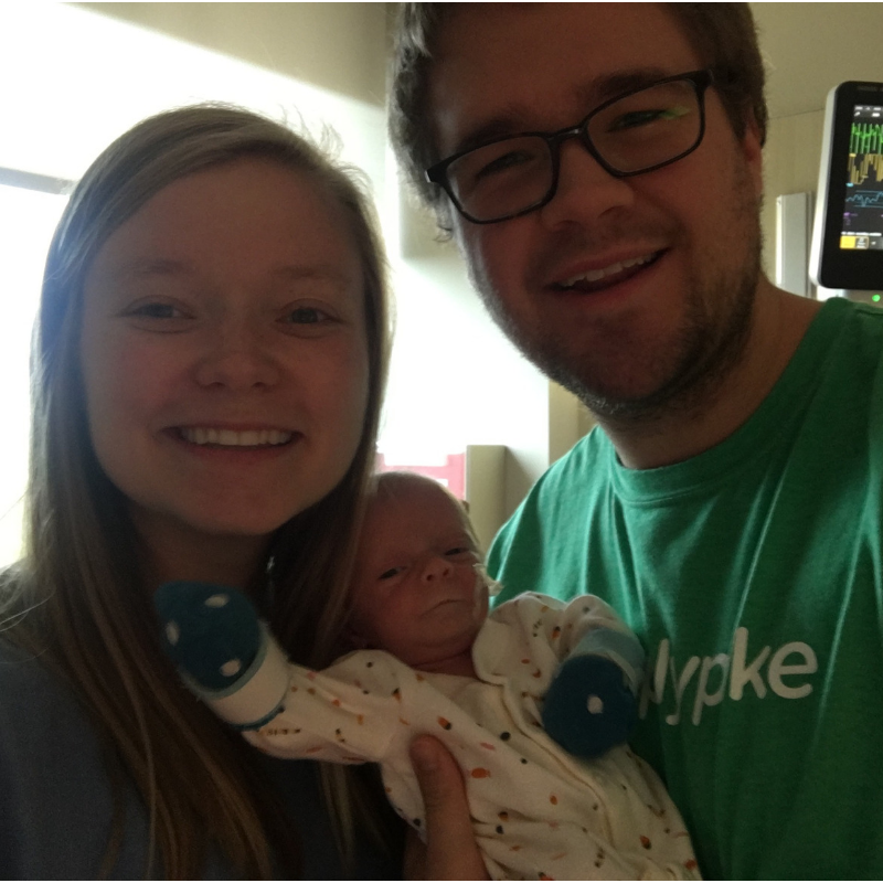 Mother and father holding newborn premature daughter