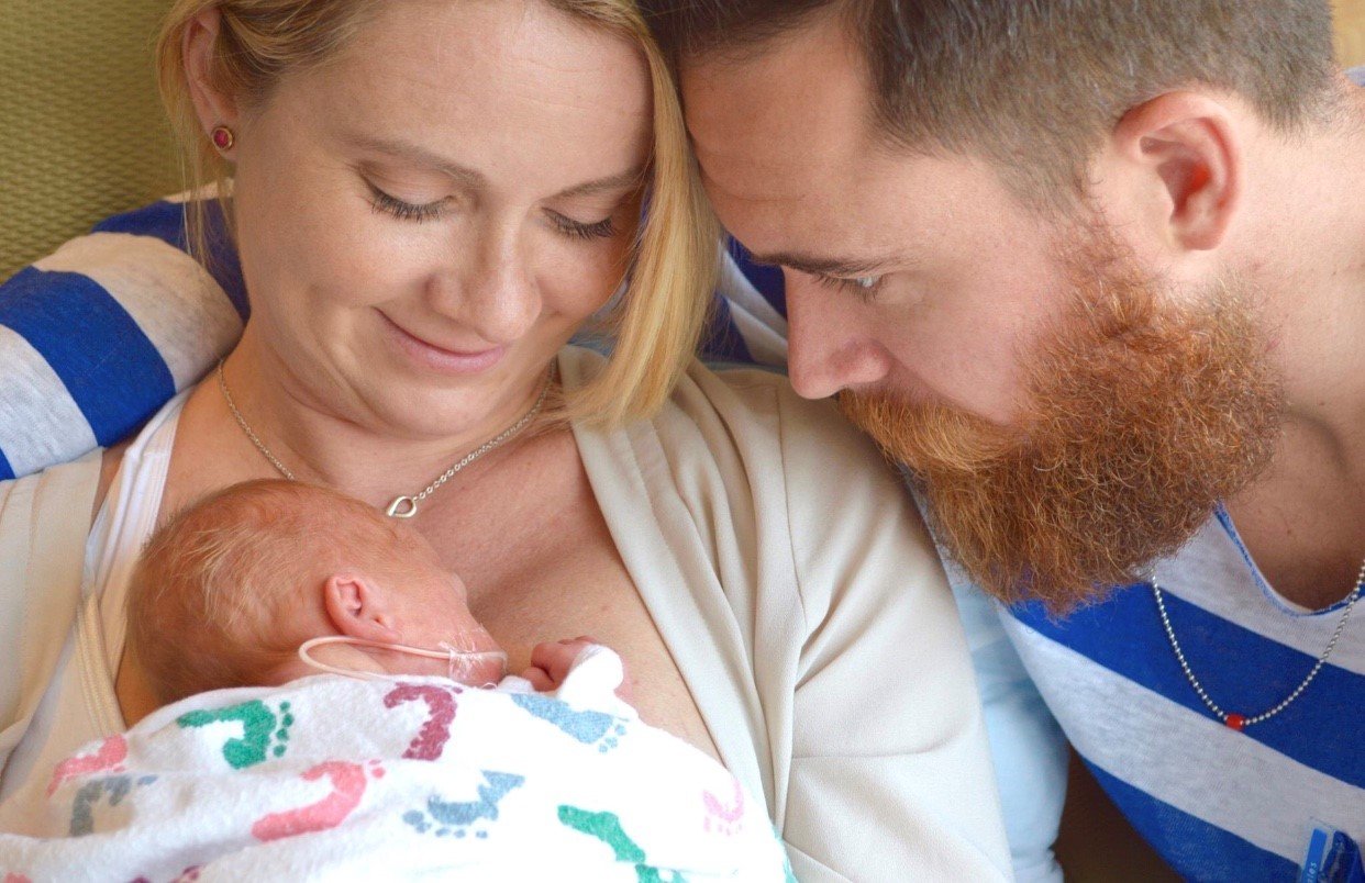 Mother and father holding newborn son