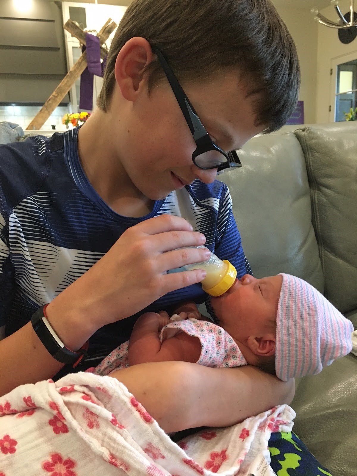 Older brother feeding baby sister