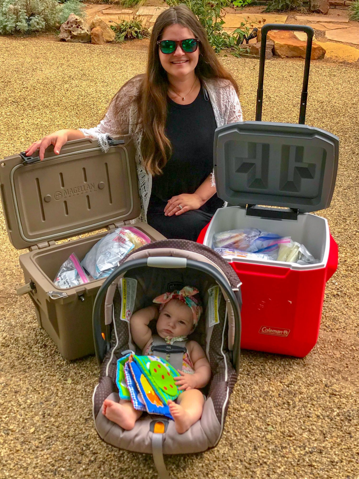 Mother and baby posed next to two coolers of breastmilk