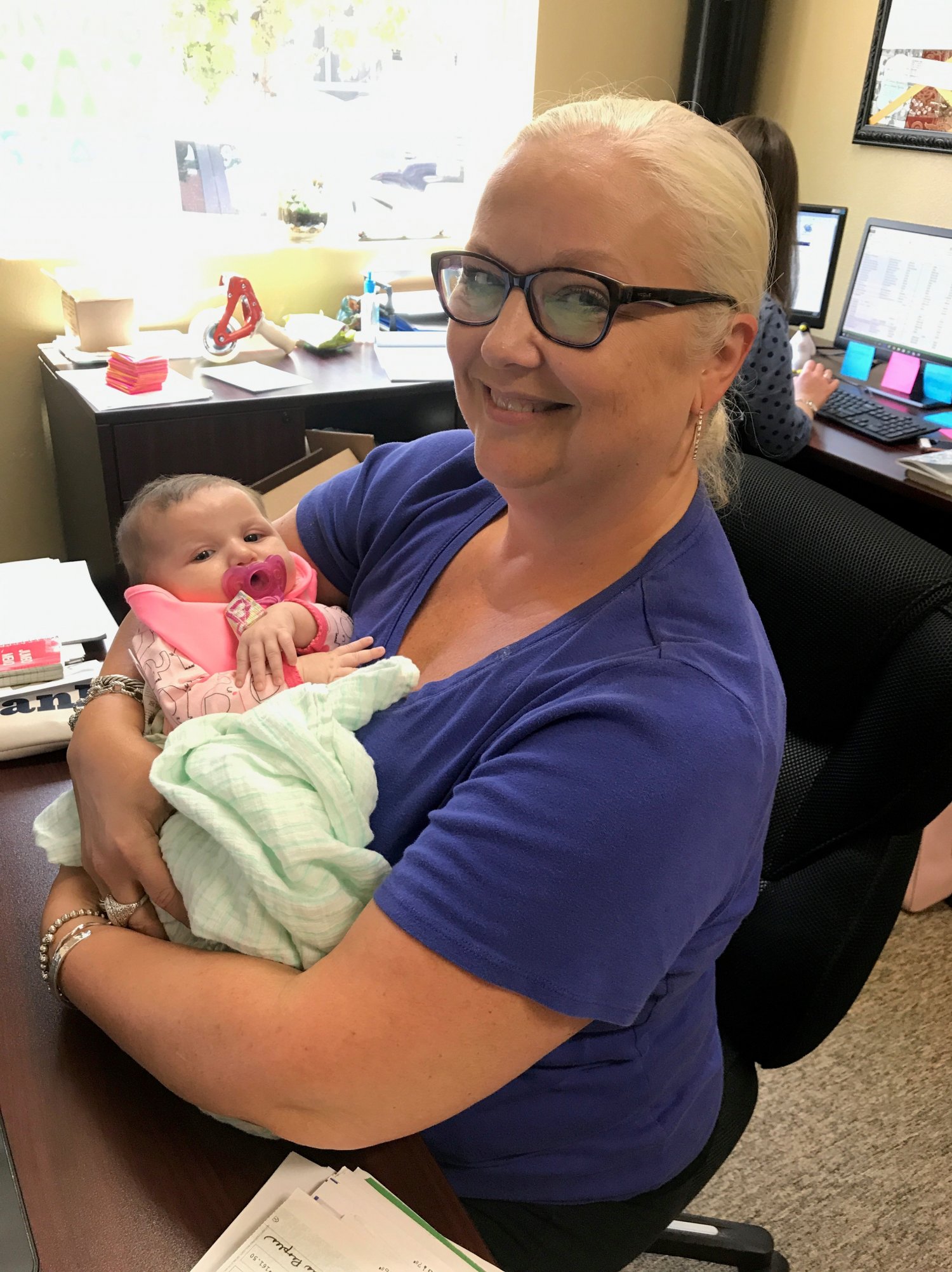 Woman holding baby in office