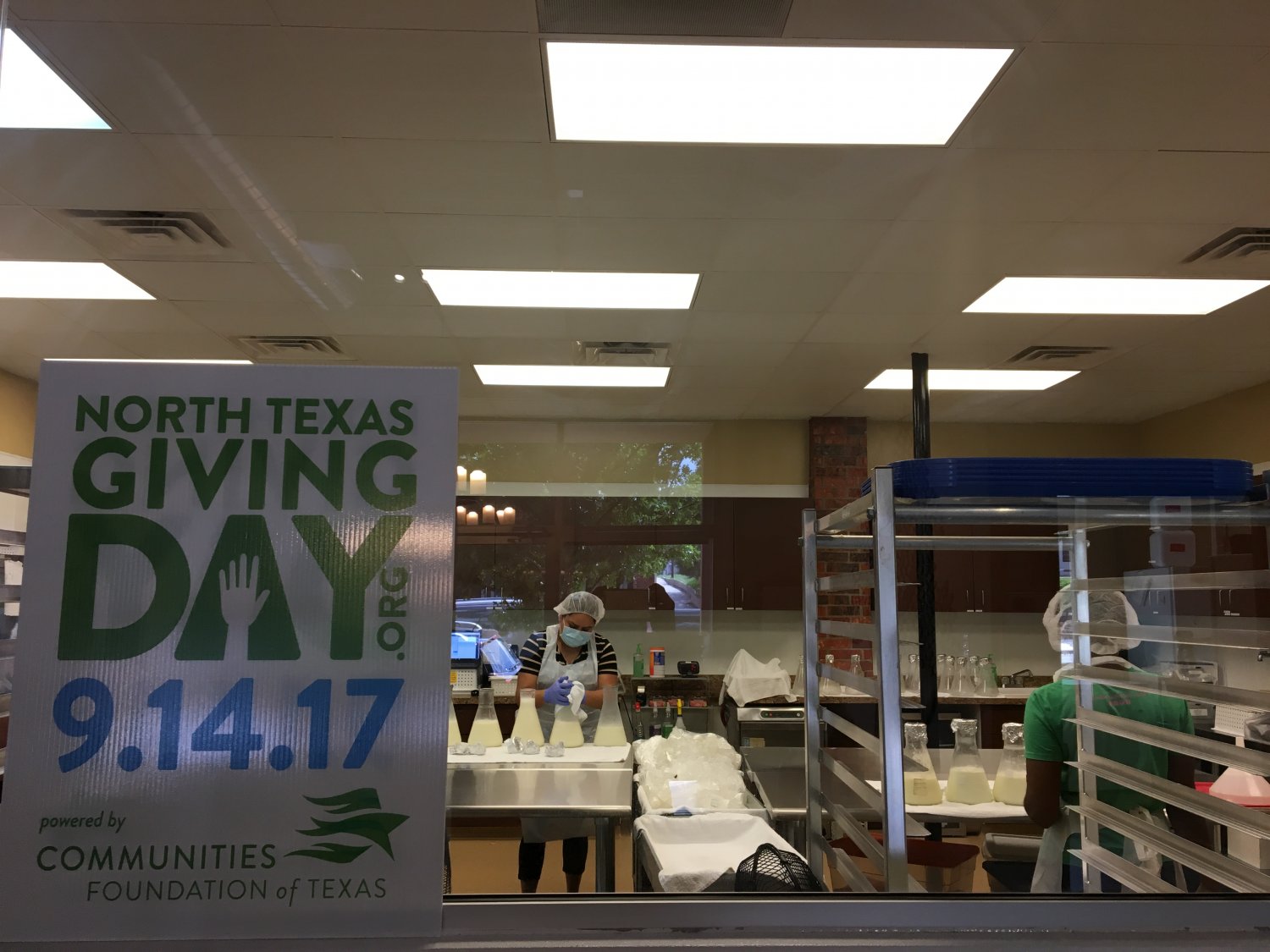 Sign for North Texas Giving Day placed on window into milk processing lab