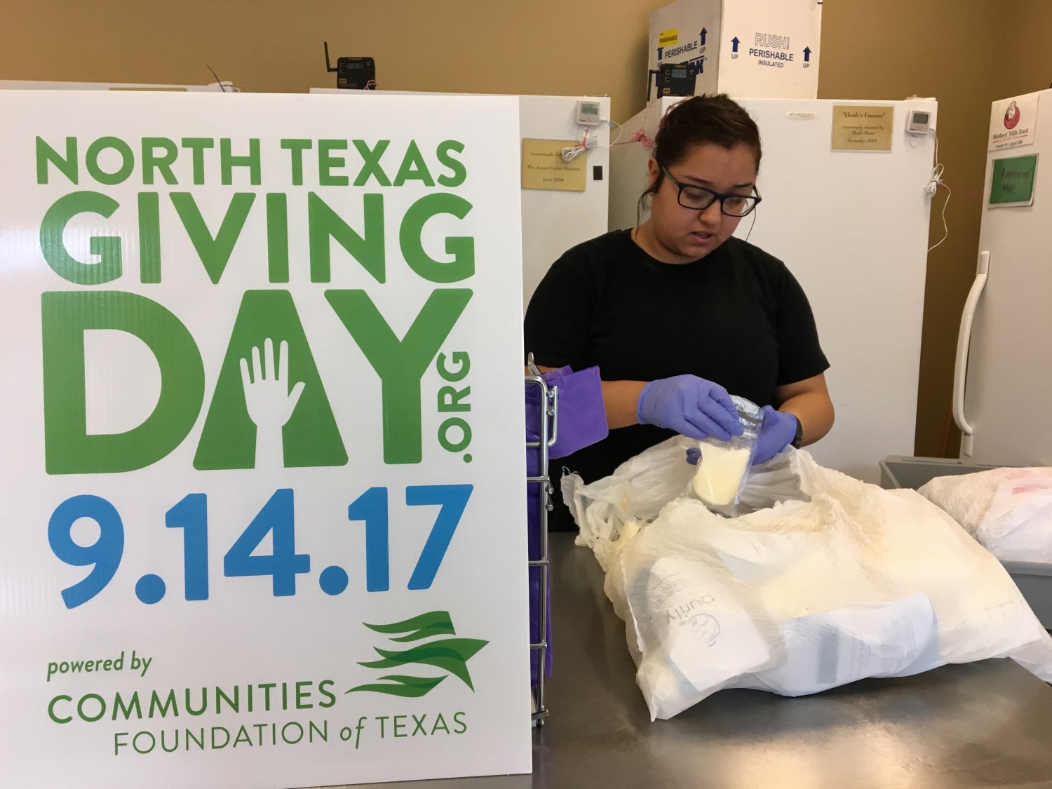 Employee checking pump dates on bags of donated breastmilk