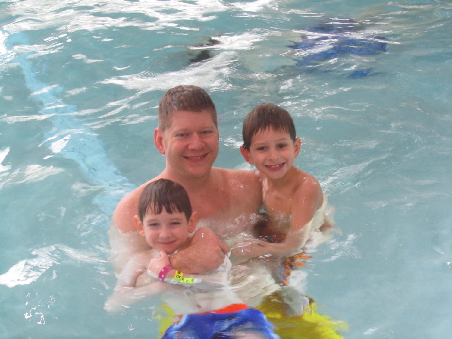 Father with two sons in swimming pool
