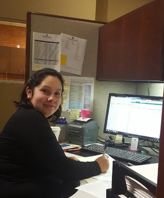 Woman sitting at office desk in front of computer