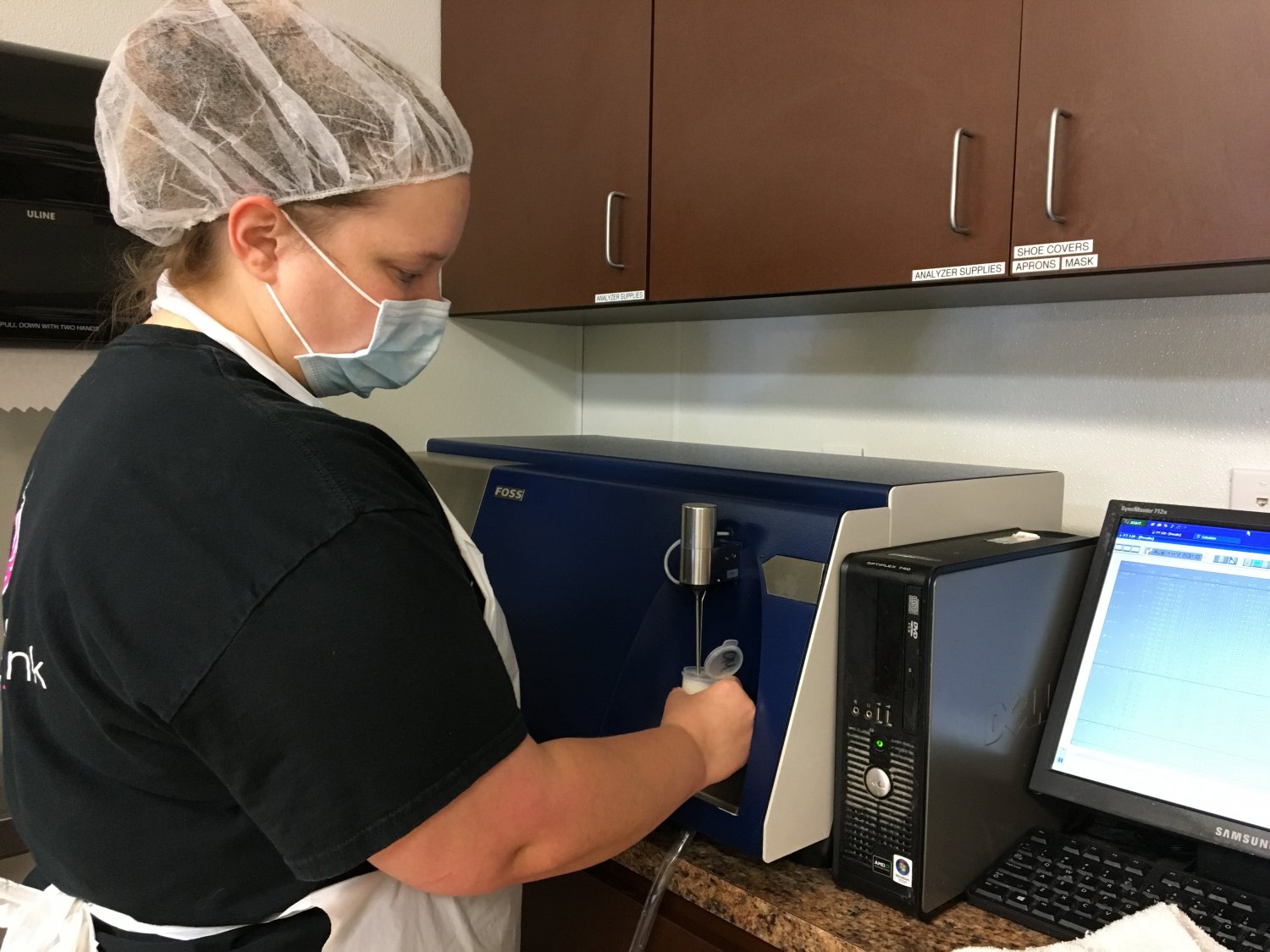 Lab technician running breastmilk sample through nutritional analyzer