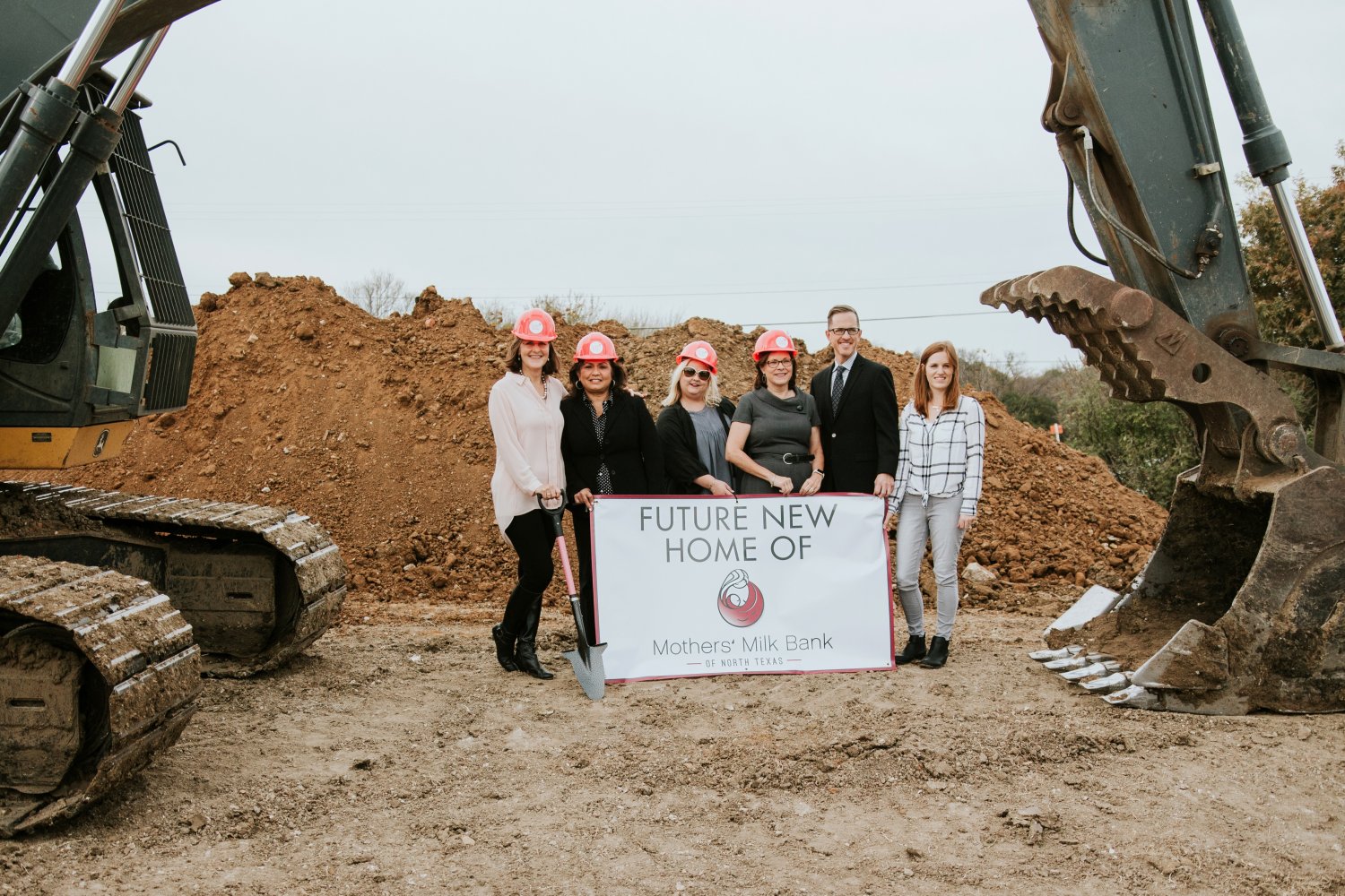 Group standing by a crane on a construction site