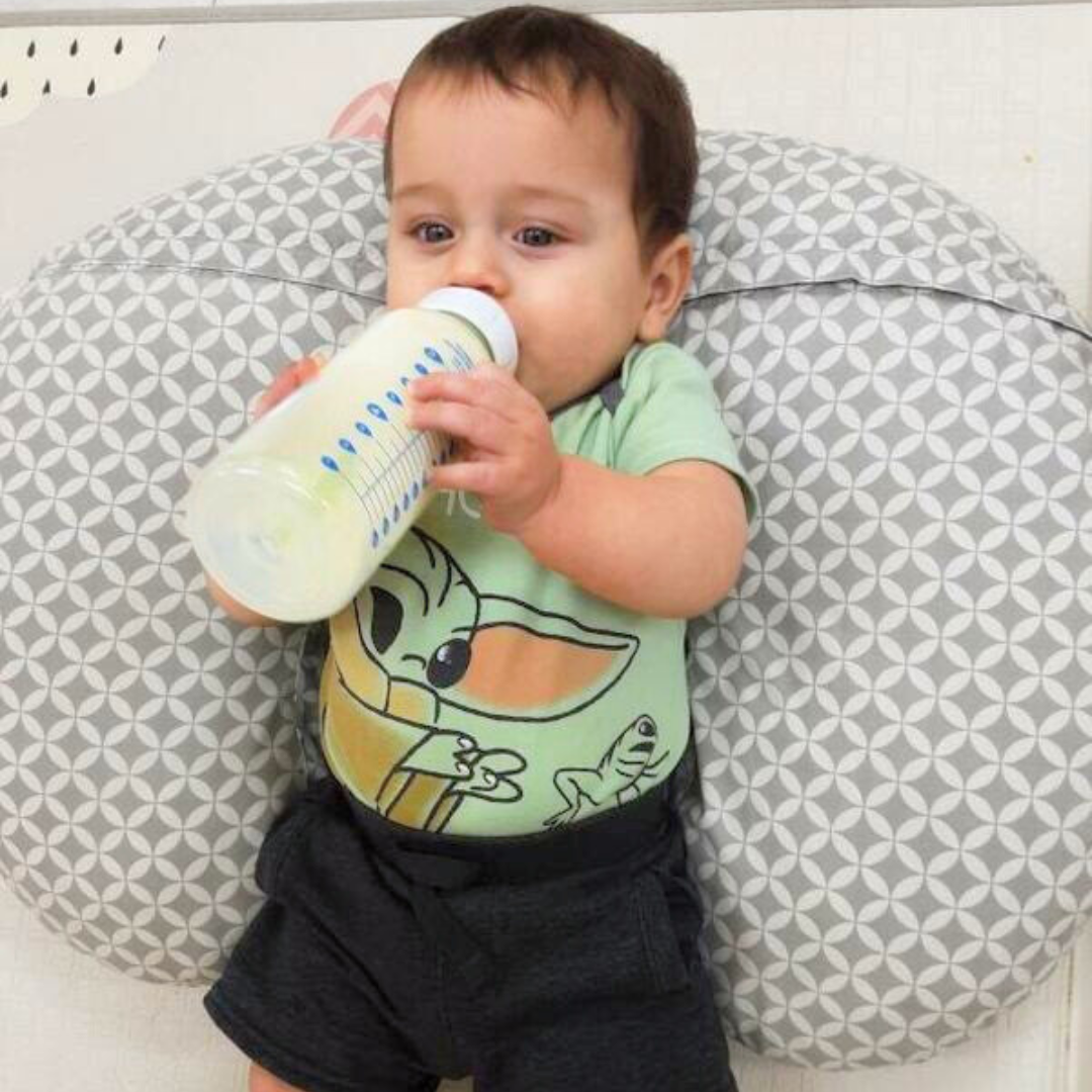 Caio, 8 mo., holding his bottle of donor milk.