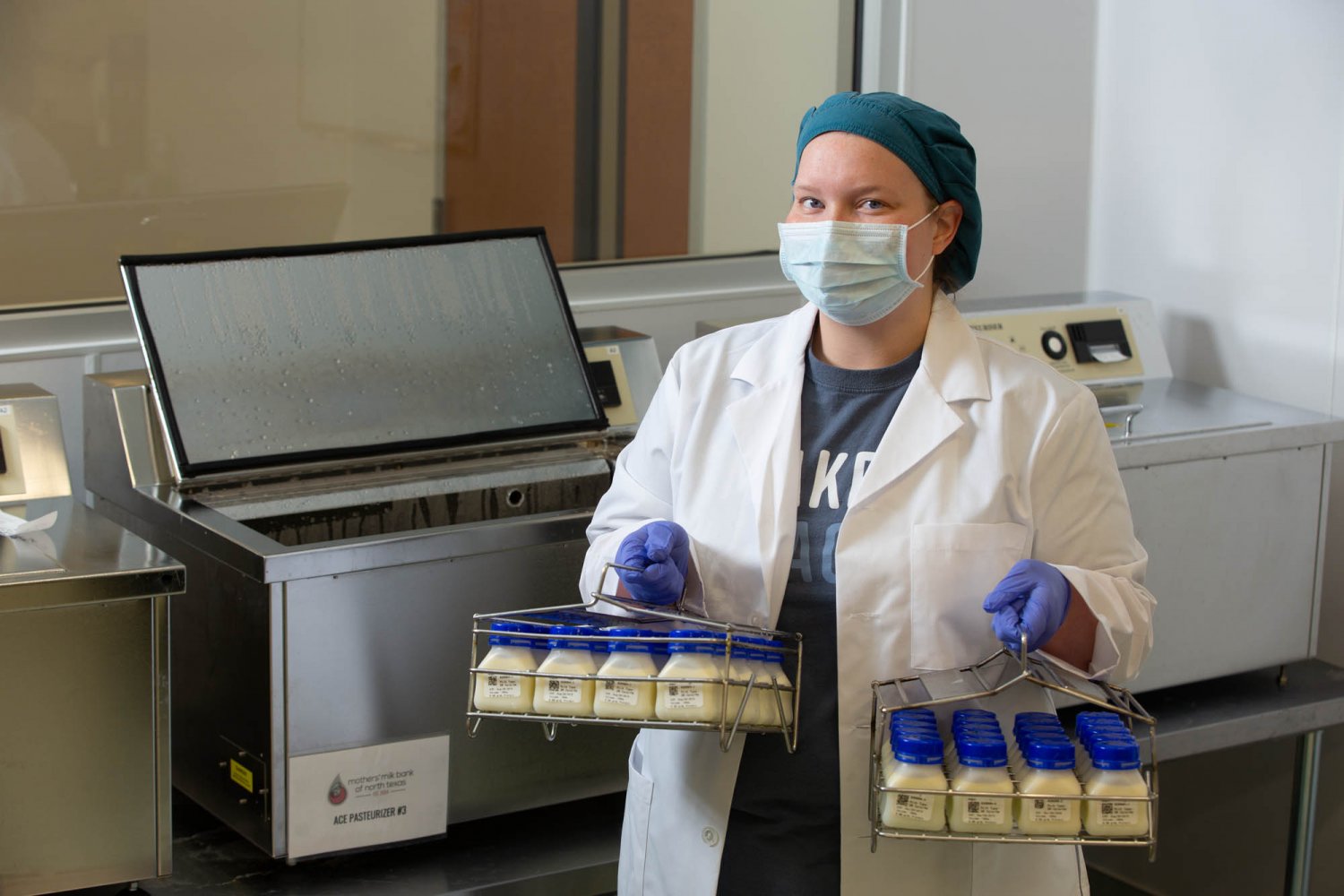 Woman removing bottles from pasteurizer