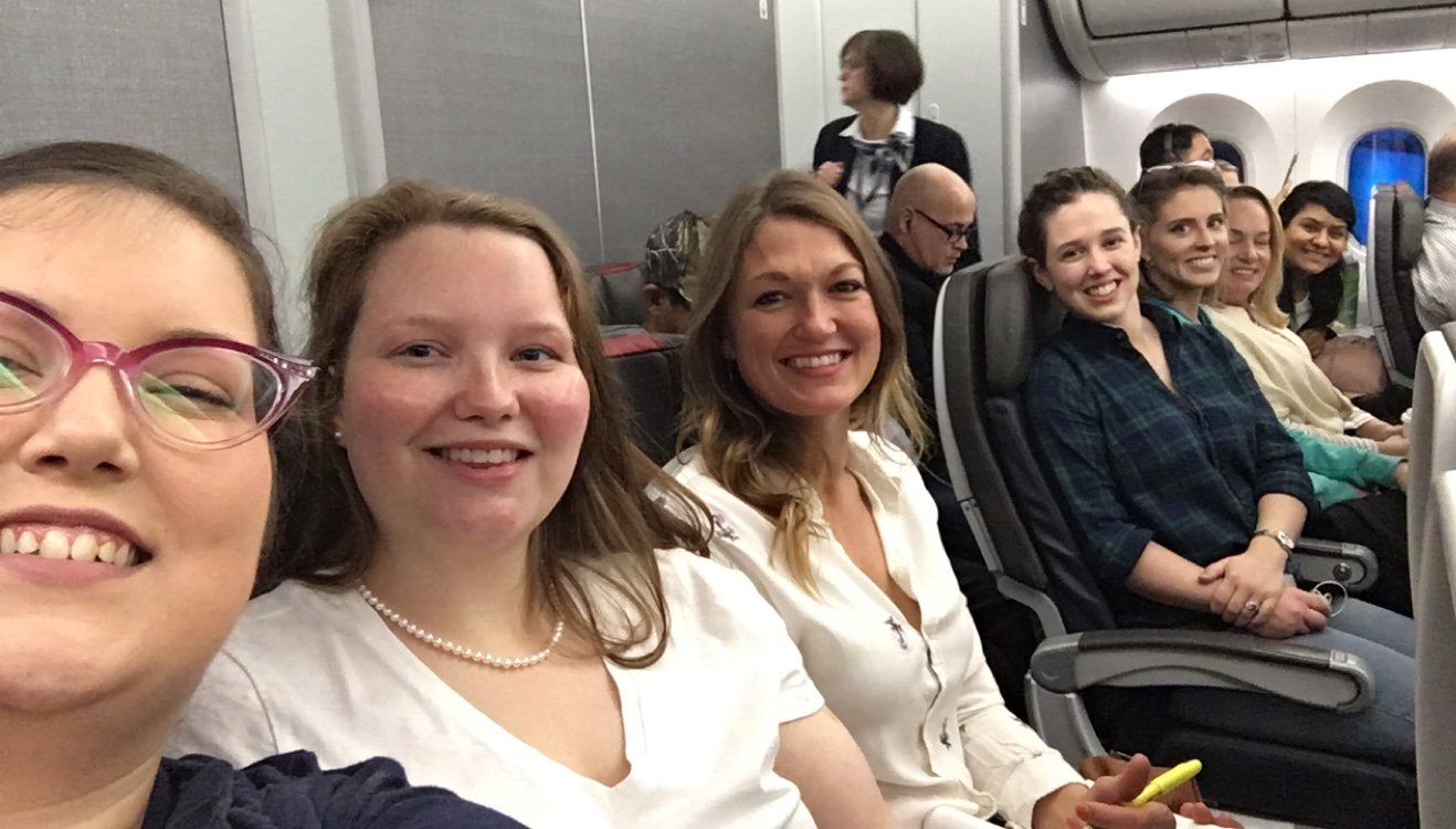 Seven women sitting on an airplane