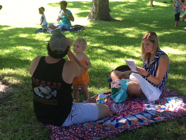 Mom, dad, and toddler on a picnic blanket