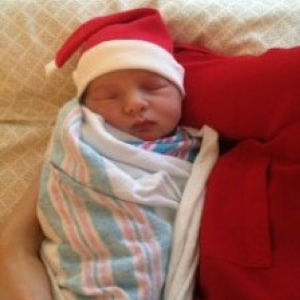 Newborn baby wearing Santa hat