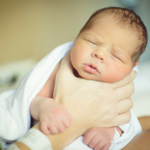 Newborn baby being held up by mother