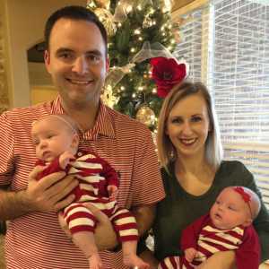 Mother and father each holding one twin daughter